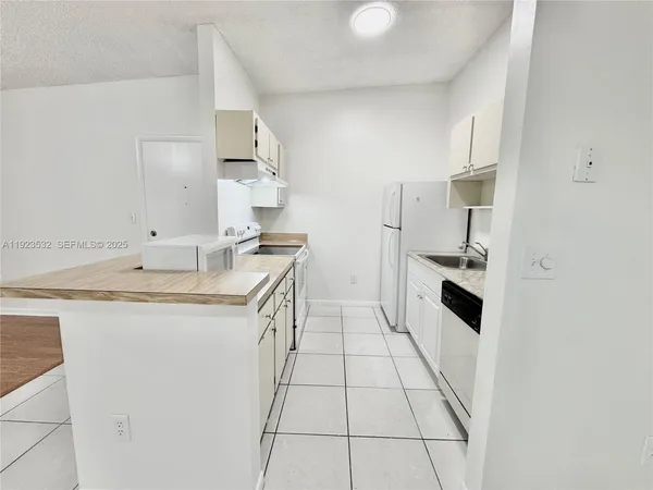 a kitchen with granite countertop a sink stove and refrigerator