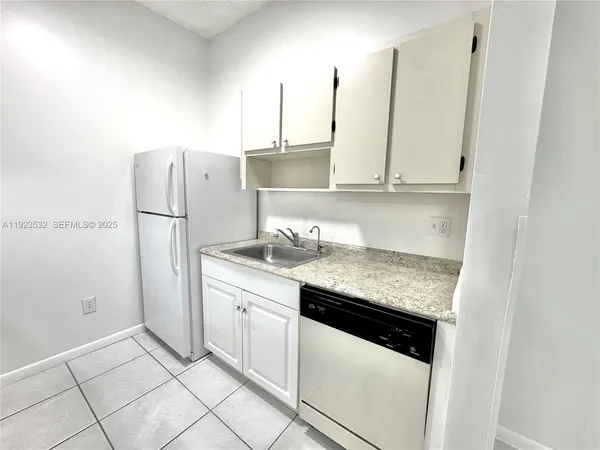 a kitchen with stainless steel appliances granite countertop a sink and a refrigerator