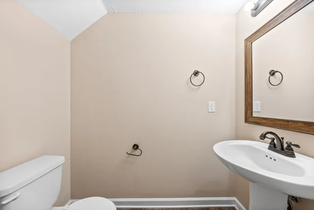 a bathroom with a sink a toilet and a mirror