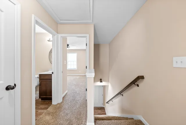 a view of a hallway with wooden floor and staircase