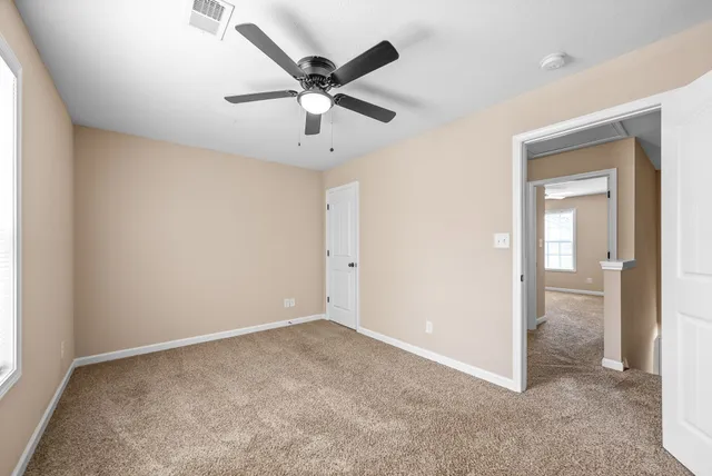 an empty room with a ceiling fan and a window