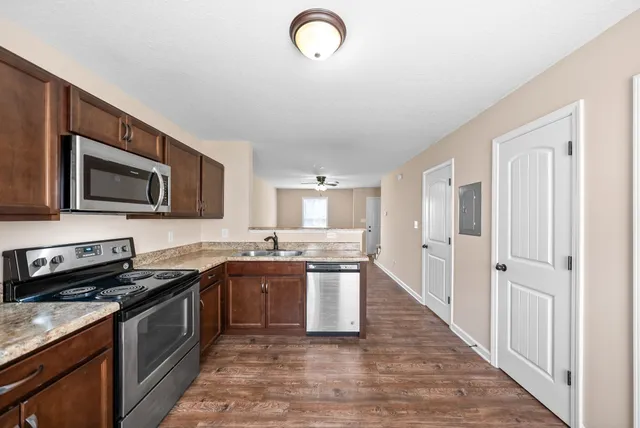 a kitchen with stainless steel appliances granite countertop a sink stove and microwave