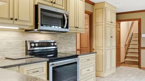 a kitchen with stainless steel appliances granite countertop a stove a sink and a microwave