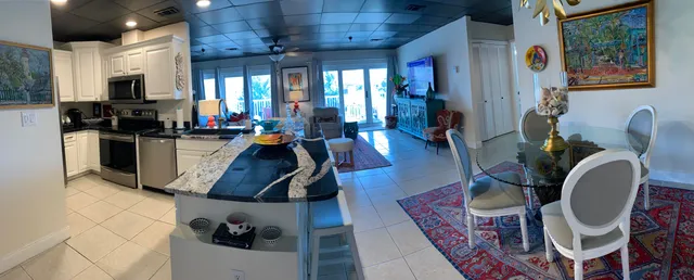 a living room with furniture a flat screen tv and kitchen view