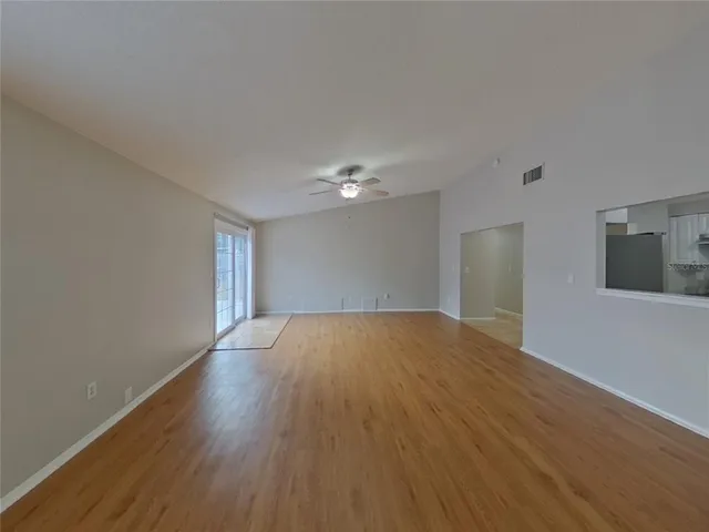 a view of empty room with wooden floor