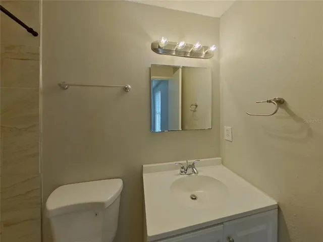 a bathroom with a sink a toilet and mirror