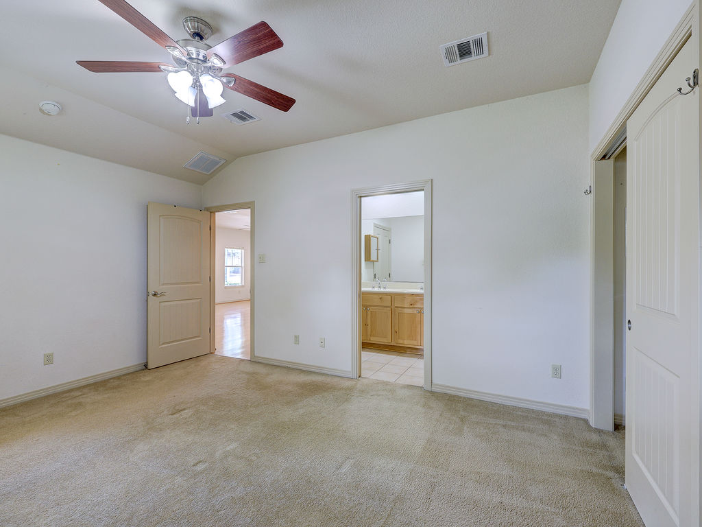 9707 Anderson Mill Road, Unit 22 Austin, TX 78750 - Photo 31 of 39 A well-lit bedroom features plush carpeting and convenient access to an en-suite bathroom.