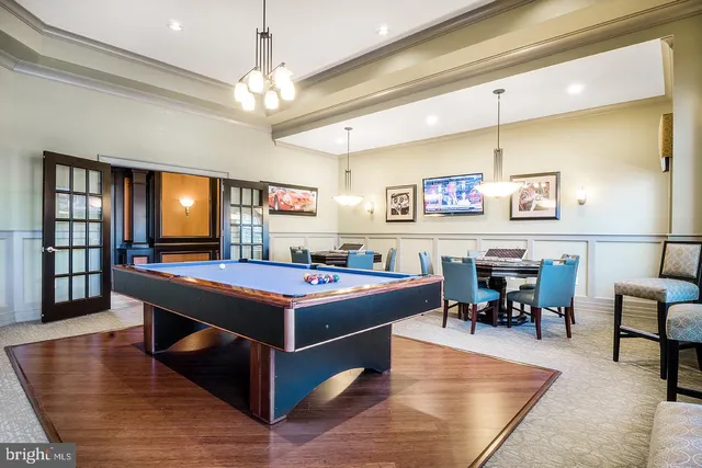 a room with furniture pool table and window