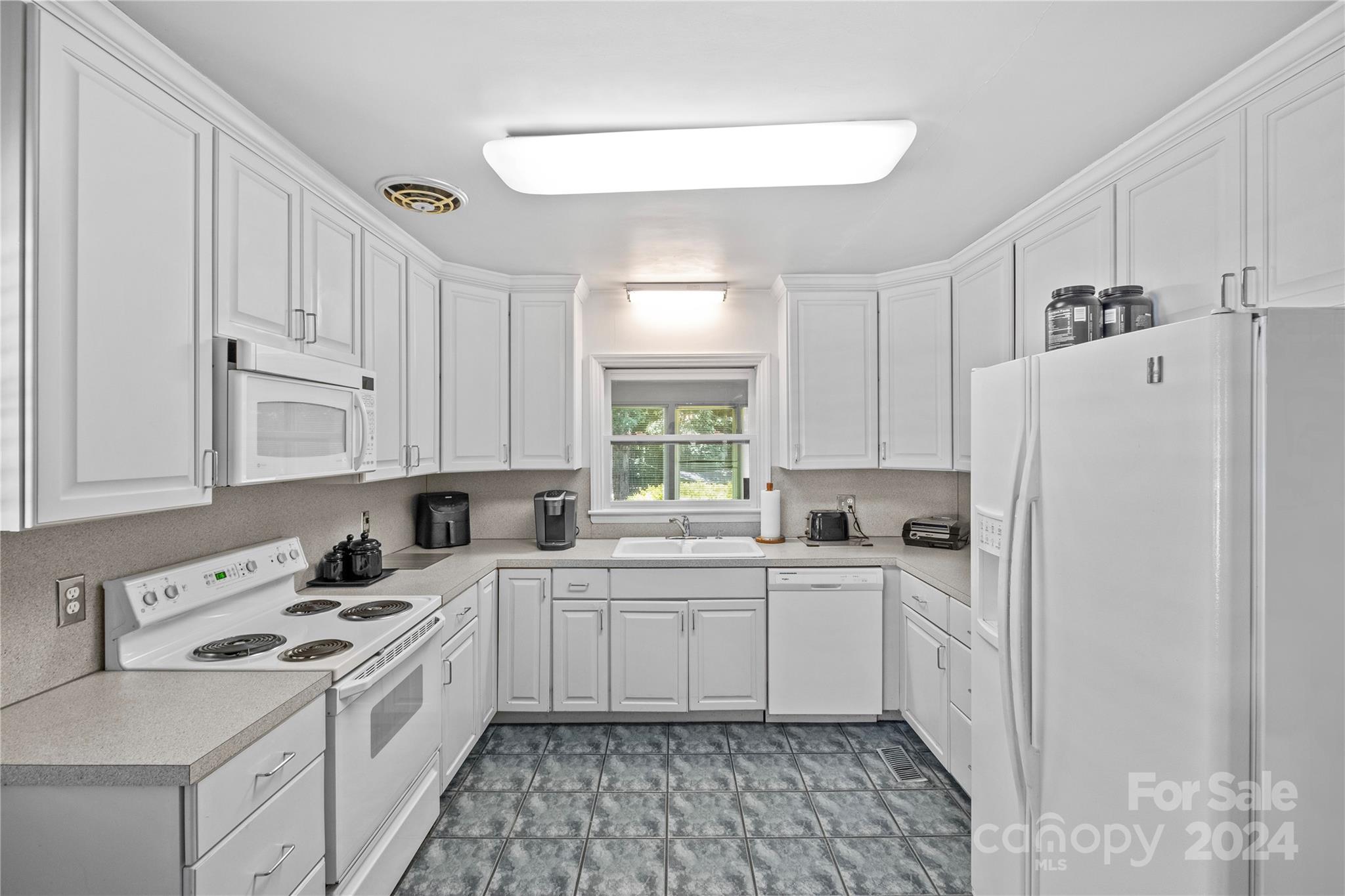 1321 Ferncliff Road Charlotte, NC 28211 - Photo 7 of 11 a kitchen with white cabinets and white appliances