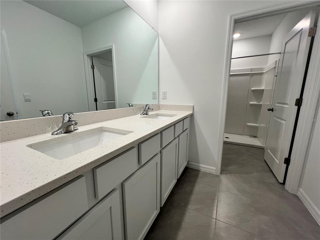 110 Mangrove Shade Circle Apollo Beach, FL 33572 - Photo 20 of 36 a en suite bathroom with a double vanity sink a toilet and a mirror