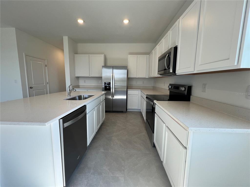 110 Mangrove Shade Circle Apollo Beach, FL 33572 - Photo 7 of 36 a kitchen with stainless steel appliances granite countertop a stove a sink and a refrigerator