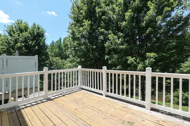 a balcony with wooden floor and fence