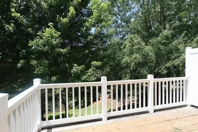 a wooden deck with trees in the background