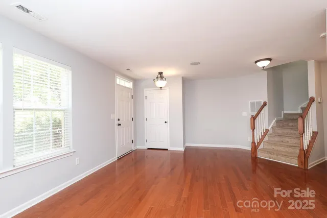 a view of empty room with wooden floor and window