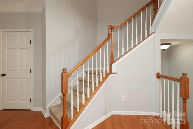 a view of staircase with railing and white walls