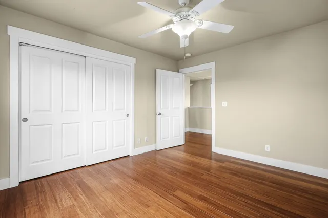 a view of an empty room with wooden floor