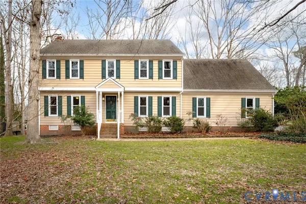 a front view of a house with a yard and trees