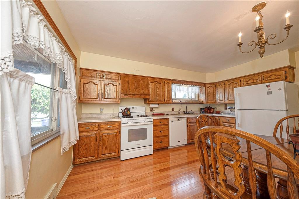 699 Kaye Avenue Monaca, PA 15061 - Photo 12 of 43 a kitchen with stainless steel appliances granite countertop a refrigerator a stove top oven a sink a dining table and chairs with wooden floor