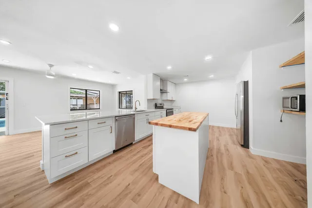 a kitchen with white cabinets and sink
