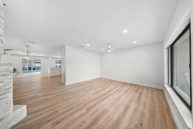 a view of empty room with wooden floor and windows