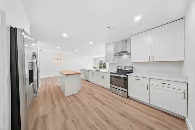 a kitchen with a refrigerator and white cabinets