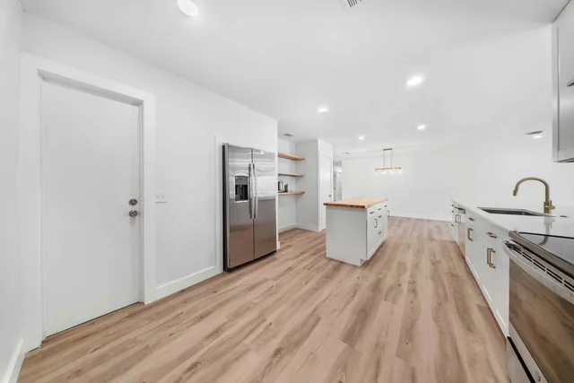 a kitchen with a sink and wooden floor