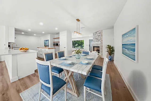 a view of a dining room and livingroom with furniture wooden floor a rug and a chandelier
