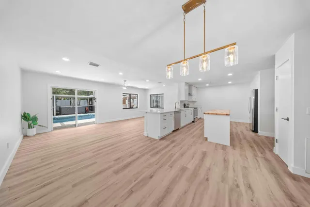 a view of a kitchen with wooden floor and a window