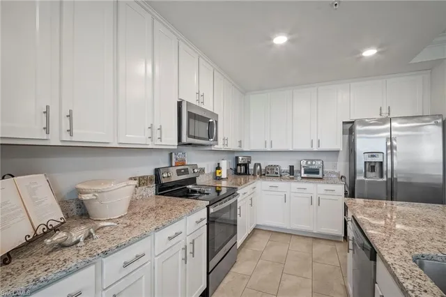 a dining room with furniture a large window and a chandelier
