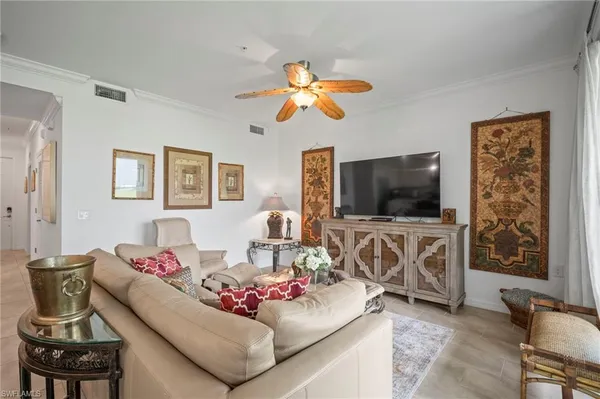 a living room with furniture flat screen tv and window