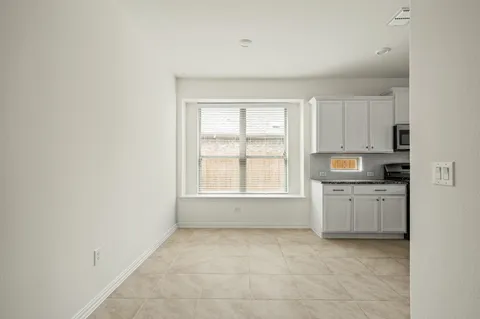 a kitchen with granite countertop a sink cabinets stainless steel appliances and a window