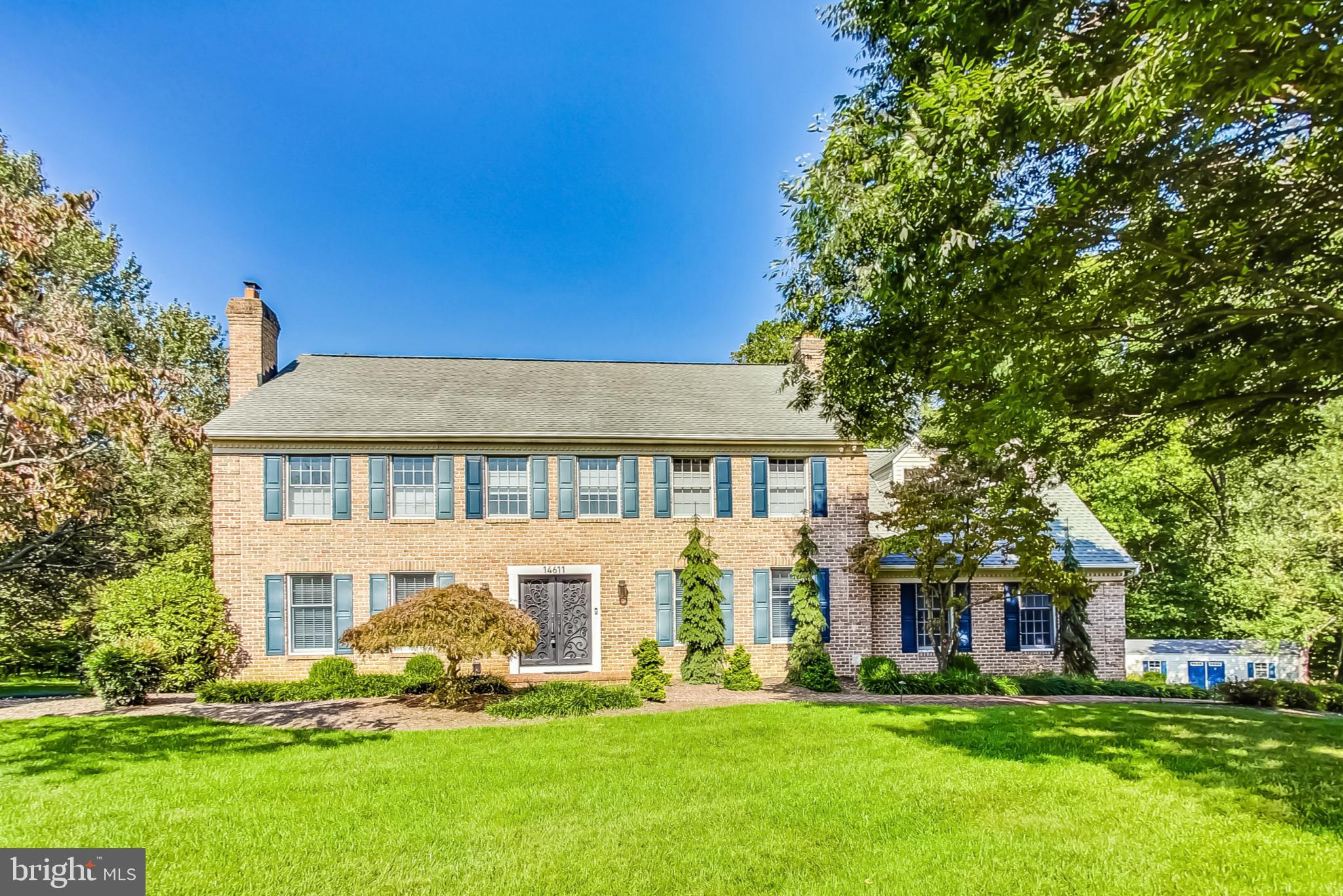 a view of a house with a big yard and large trees