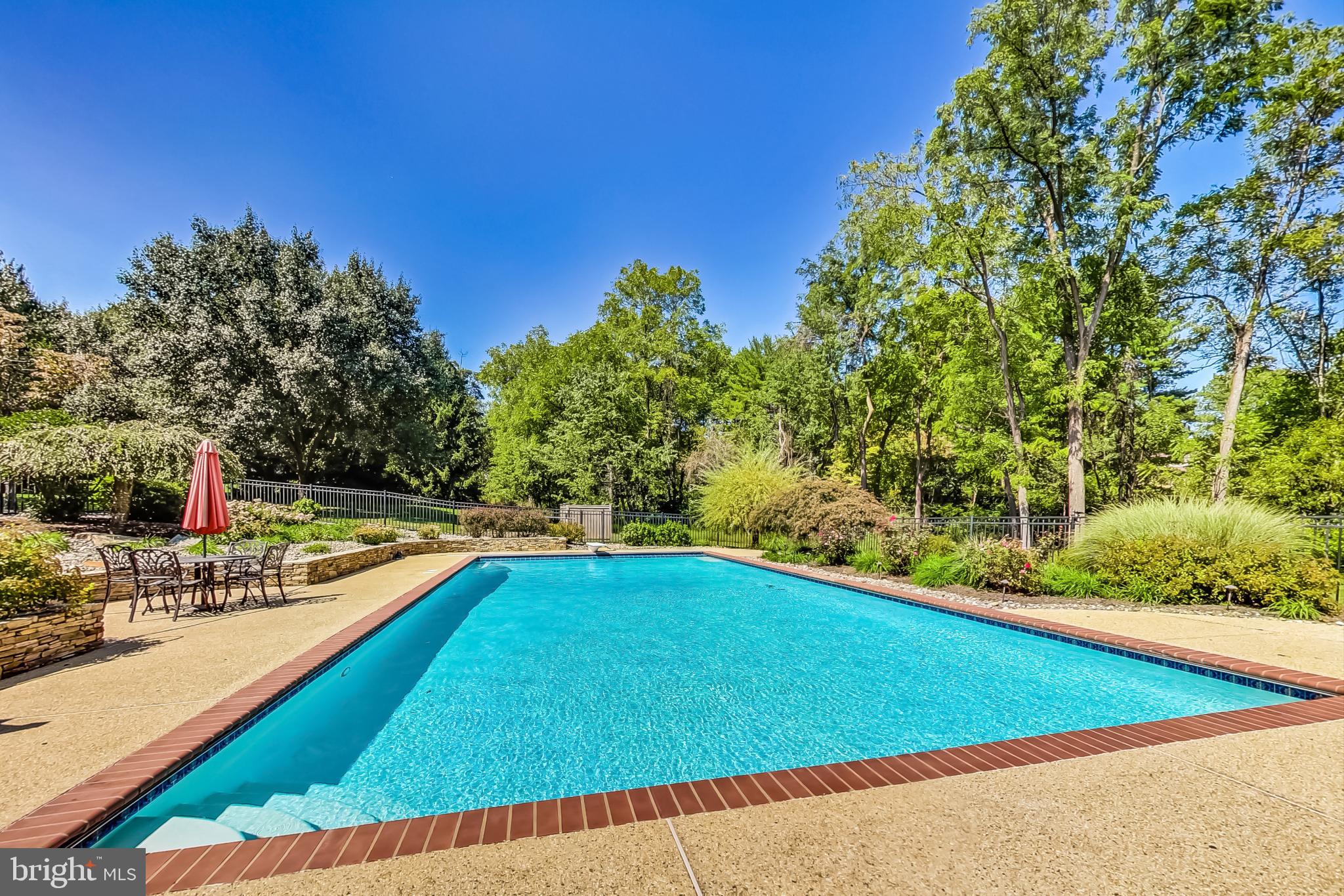14611 Manor Road Phoenix, MD 21131 - Photo 62 of 85 a view of a swimming pool with an outdoor seating and a forest