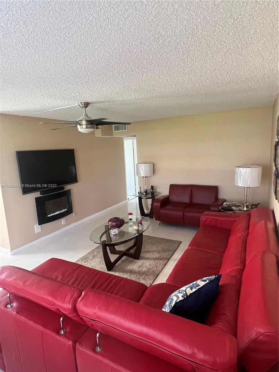 179 Dorset East, Unit 179 Boca Raton, FL 33434 - Photo 1 of 13 a living room with furniture and a flat screen tv