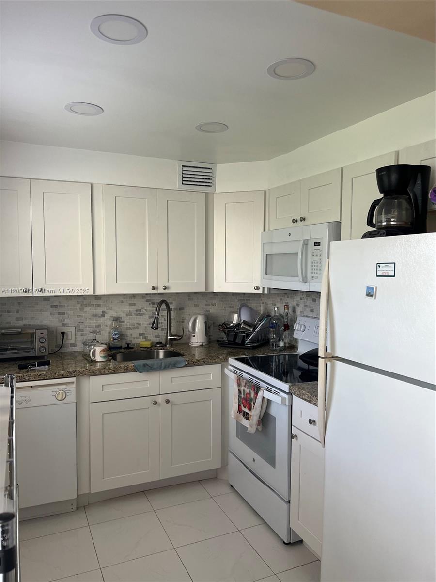 179 Dorset East, Unit 179 Boca Raton, FL 33434 - Photo 3 of 13 a kitchen with a sink a stove and cabinets