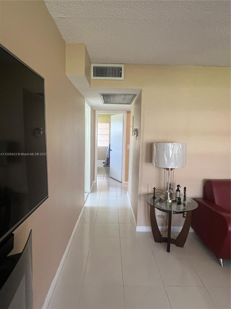 179 Dorset East, Unit 179 Boca Raton, FL 33434 - Photo 5 of 13 a living room with furniture and a flat screen tv