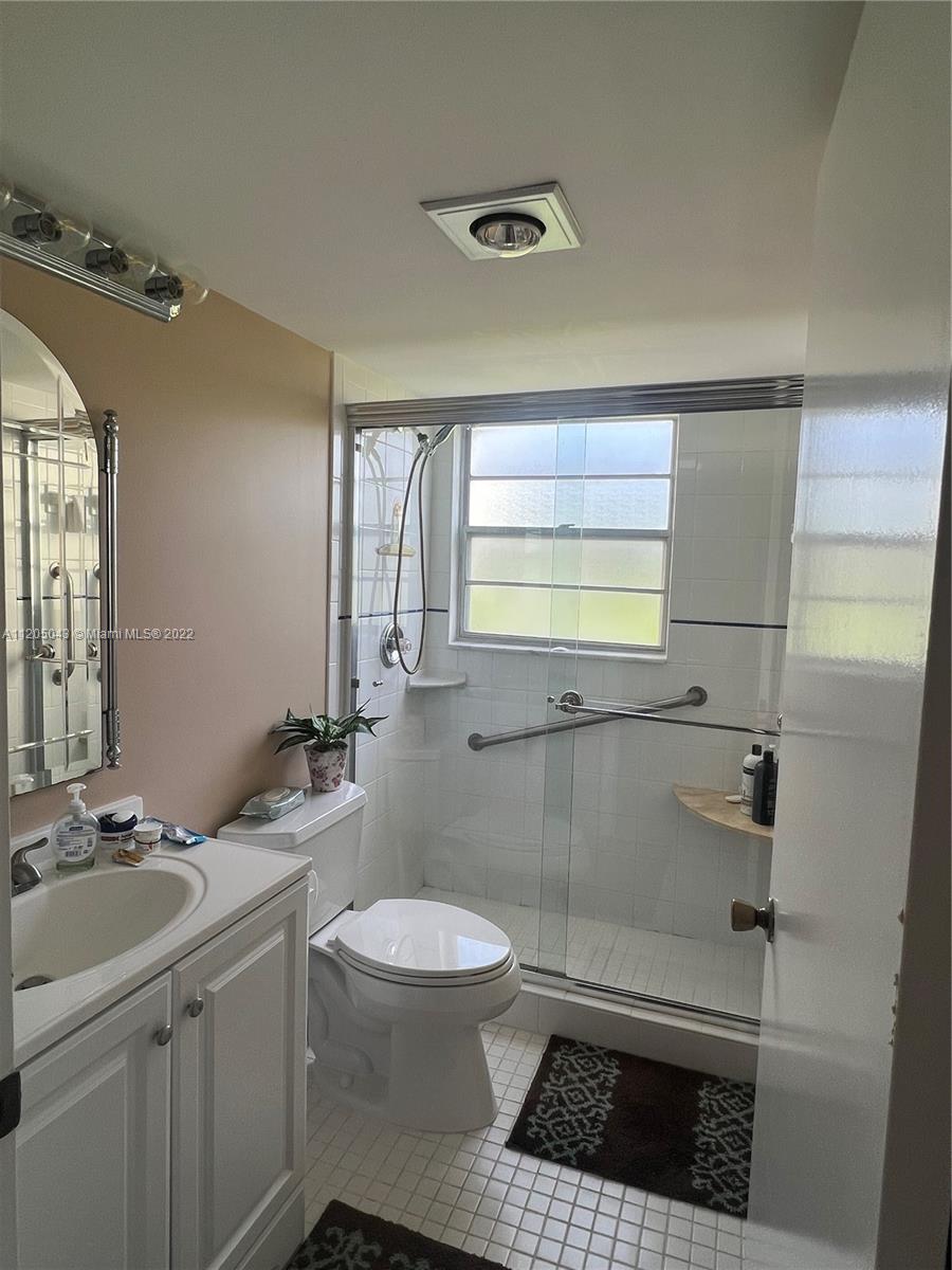 179 Dorset East, Unit 179 Boca Raton, FL 33434 - Photo 7 of 13 a bathroom with a sink a toilet and shower