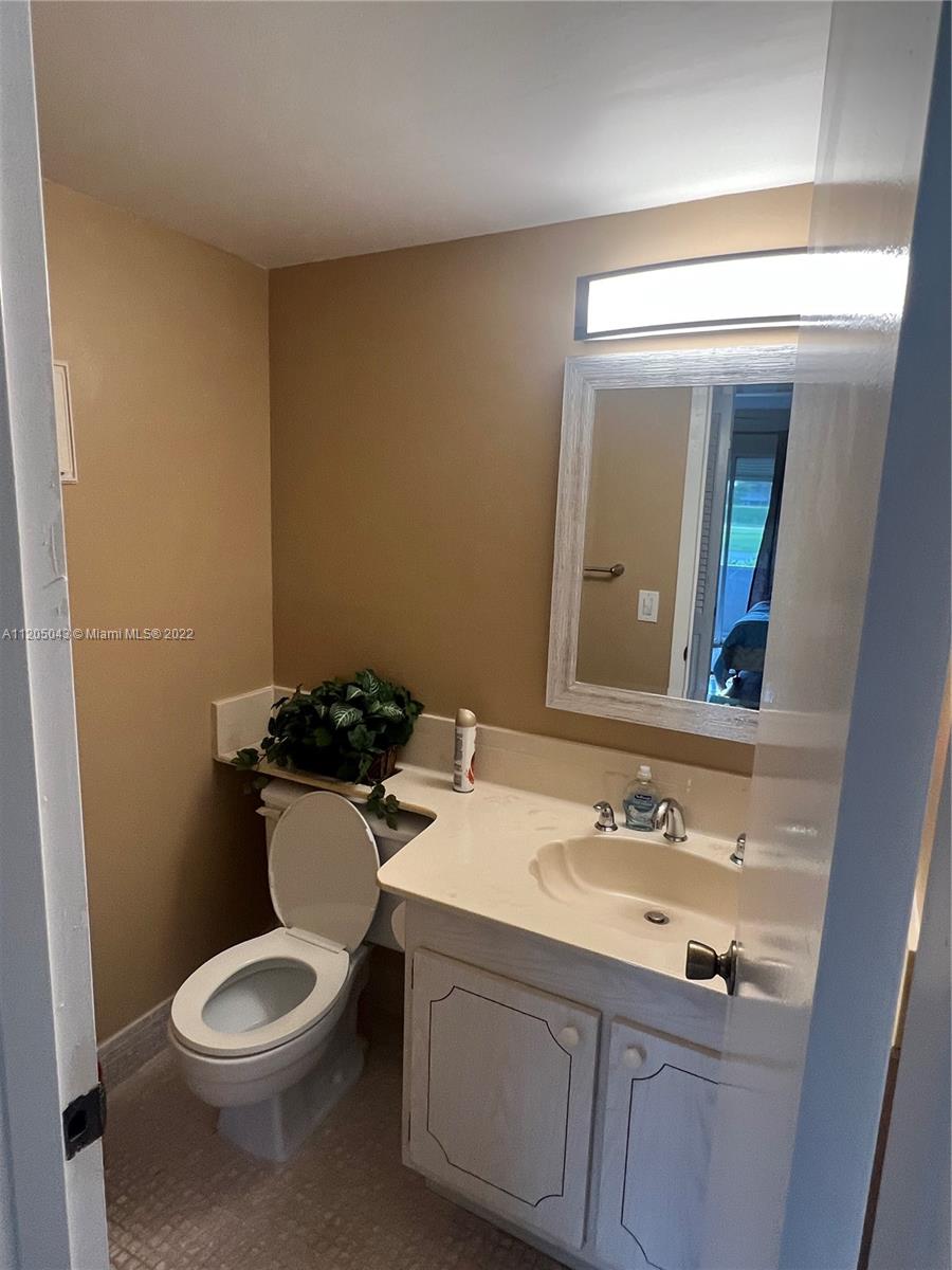 179 Dorset East, Unit 179 Boca Raton, FL 33434 - Photo 9 of 13 a bathroom with a sink a toilet and mirror