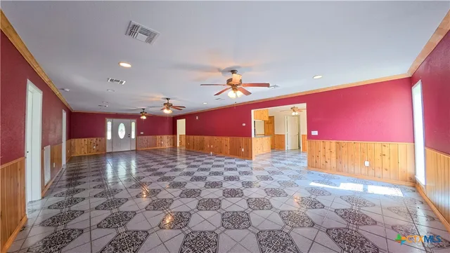 a view of a room with a gaming machine and wooden floor