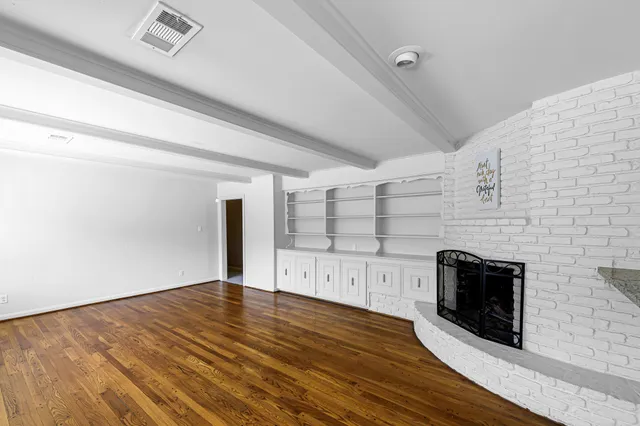 a view of a livingroom with wooden floor and a fireplace