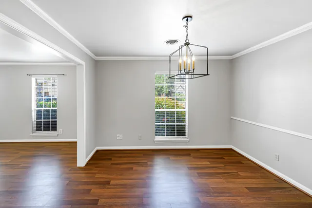 a view of empty room with wooden floor and window
