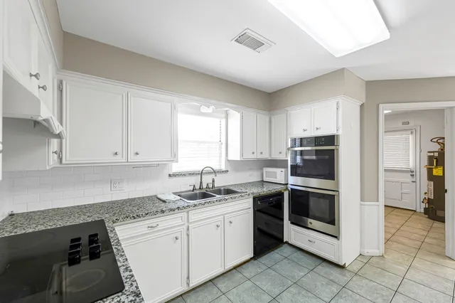 a kitchen with stainless steel appliances granite countertop a sink and a stove top oven