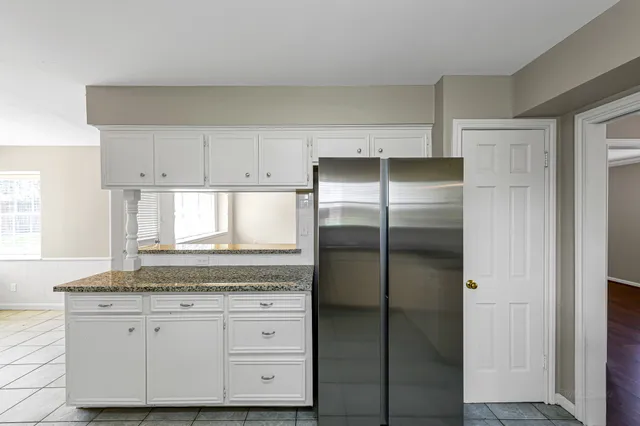 a kitchen with granite countertop white cabinets and stainless steel appliances