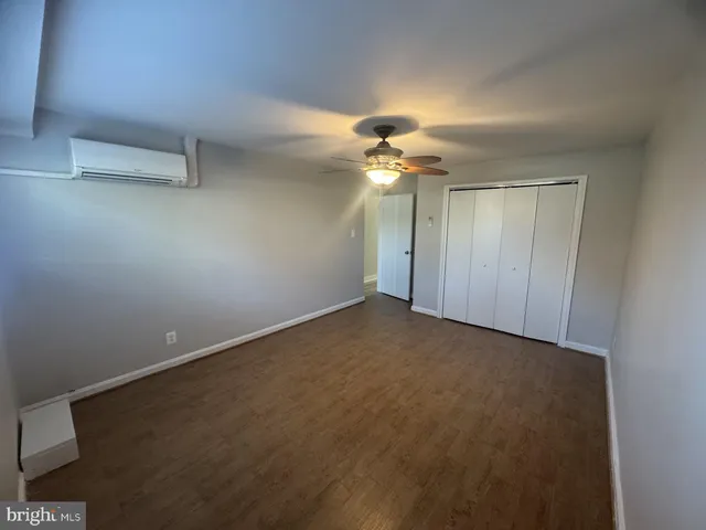 a view of an empty room with a chandelier fan