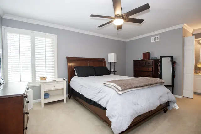 a bedroom with a large bed and a chandelier