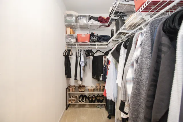 a view of walk in closet with clothes and shoes