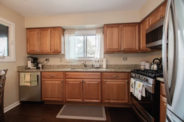 a kitchen with stainless steel appliances granite countertop a stove a sink and a microwave