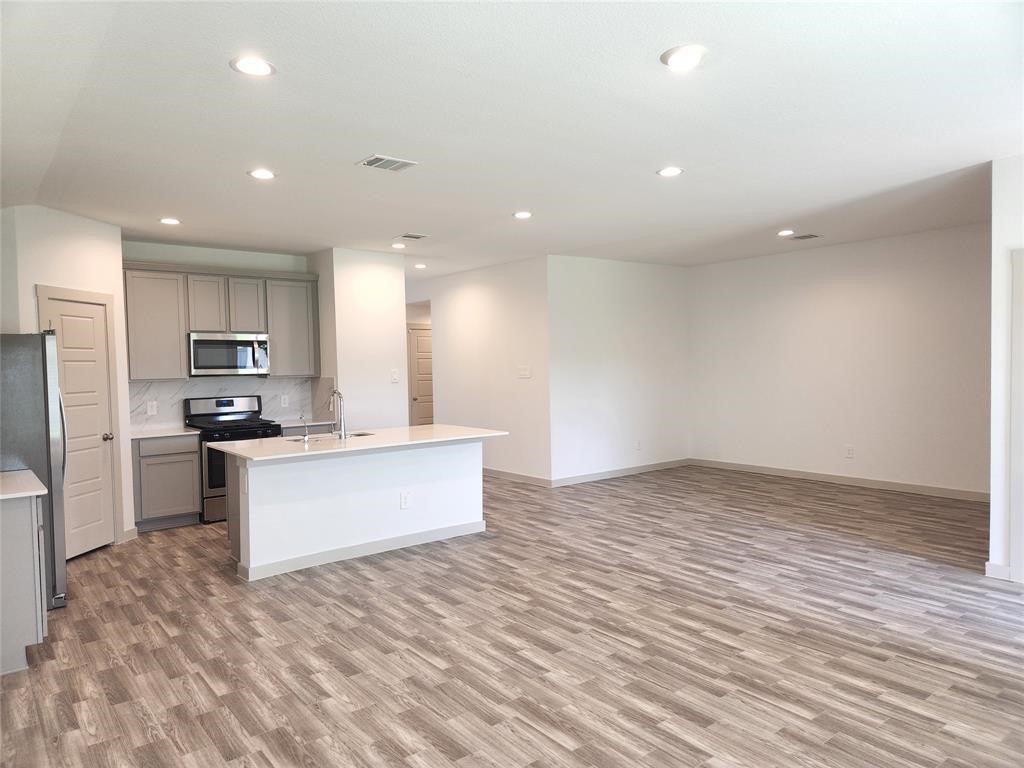 226 Serena Park Lane Rosharon, TX 77583 - Photo 6 of 19 a large kitchen with kitchen island a sink stainless steel appliances and cabinets