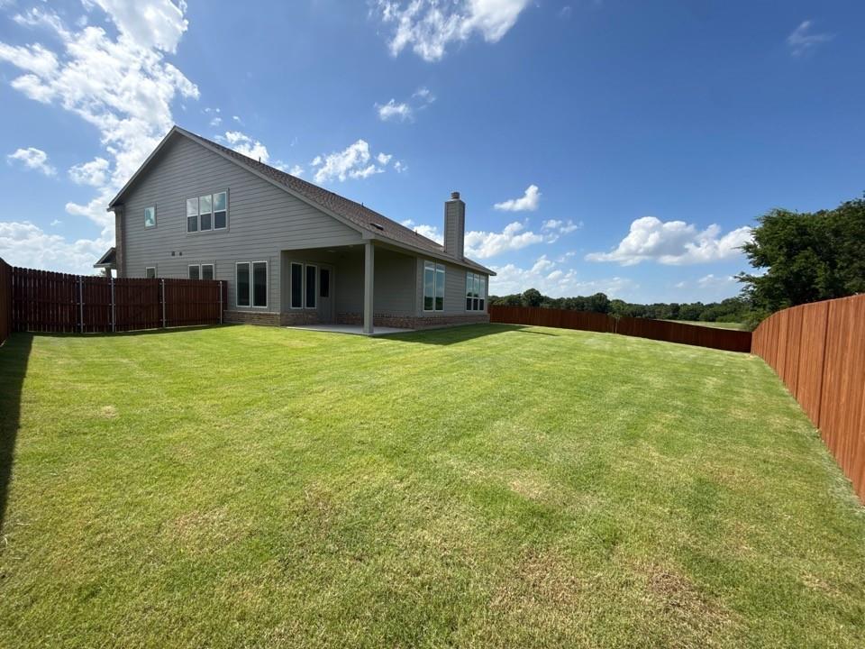 1233 Frio Drive Springtown, TX 76082 - Photo 11 of 13 Expansive backyard featuring a manicured lawn, a full wooden privacy fence, and a covered patio area