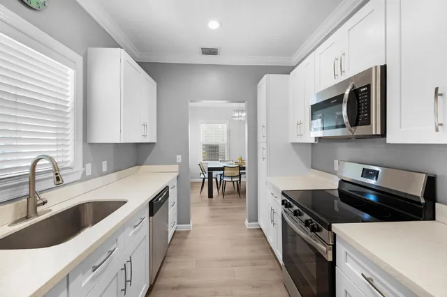 a living room with furniture a large window and wooden floor